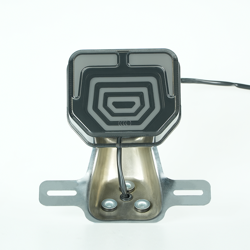 Geometric pattern motorcycle rear LED tail lamp, black smoke cover, chrome mounting holder, front view