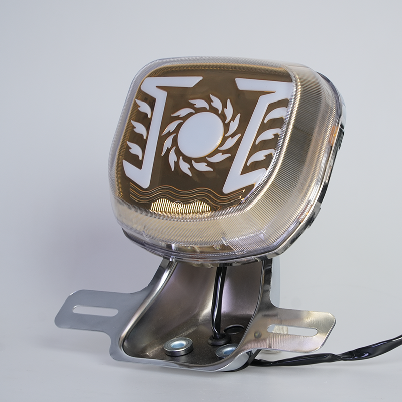 GN motorcycle LED tail light with sun flame pattern, clear lens, chrome license plate bracket, side view, blank center for custom logo