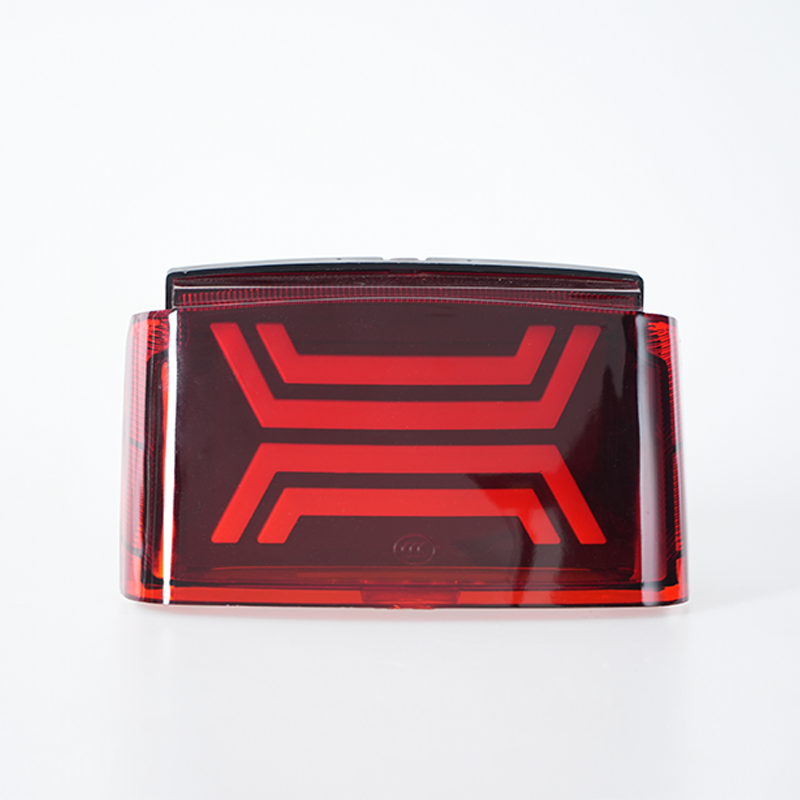Front static shot of red transparent motorcycle taillight, double‑layer geometric decorative pattern